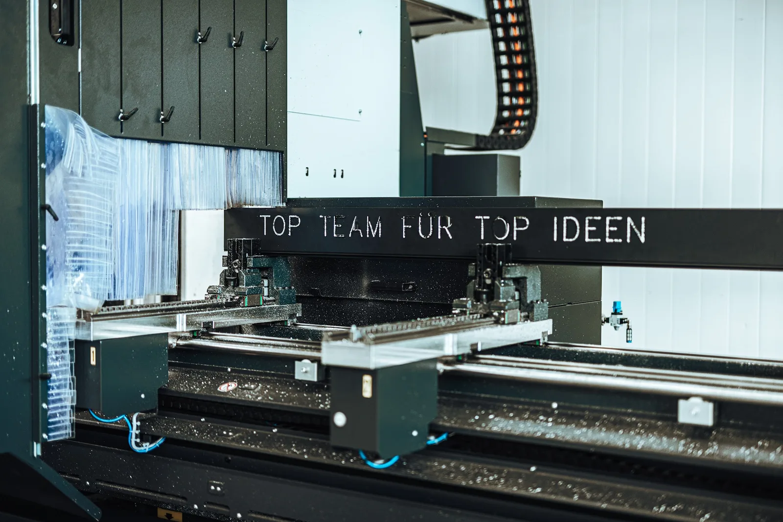 Schwarze CNC-Anlage in der Werkhalle mit der Aufschrift TOP TEAM FÜR TOP IDEEN