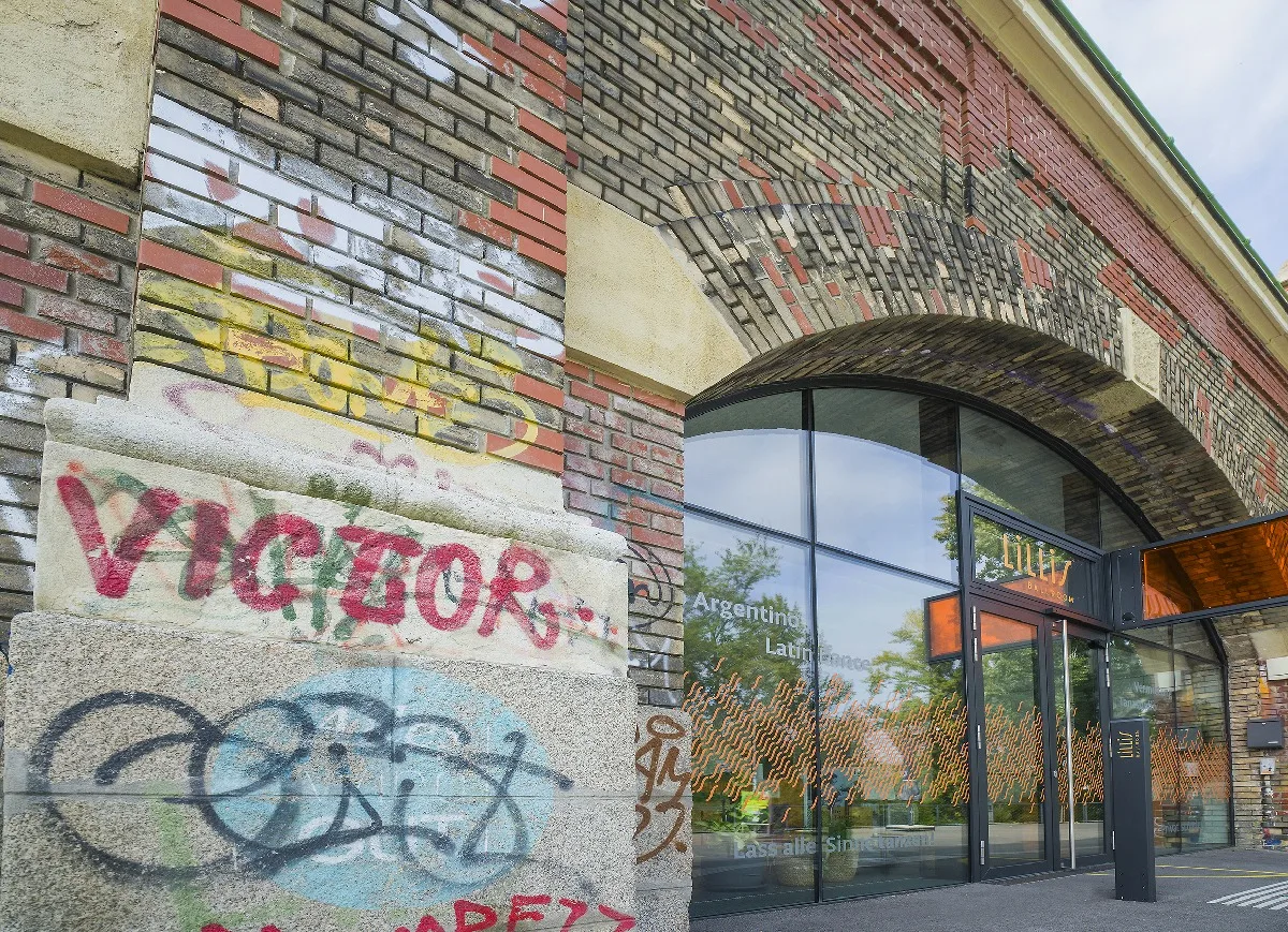 Neues Glasportal mit schmalen Alu-Profilen in einem Ziegelbogen der Wiener Stadtbahn